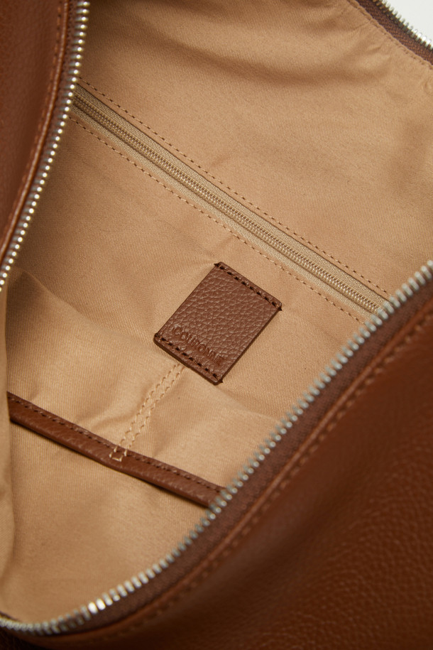 Coobo 숄더 38은 부드러운 엠보싱 소가죽 소재의 여성 숄더백입니다. 브라운 컬러의 미디엄 사이즈 가방으로, 호보백 스타일의 반원 모양 디자인과 3WAY 연출이 가능한 실용성을 갖췄습니다. 탈부착 가능한 스트랩과 내부 포켓으로 수납력을 높였으며, 클래식, 미니멀, 시크한 스타일에 잘 어울립니다. 데이트룩, 모임룩, 오피스룩 등 다양한 TPO에 활용할 수 있으며, 실버 하드웨어 장식이 은은한 포인트를 더합니다.
