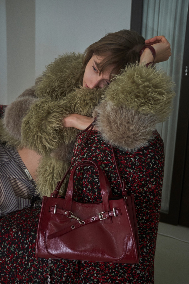 페르미에 데이 토트 27은 여성스러운 스타일을 강조하는 미디엄 사이즈의 사각 토트백입니다. 와인 컬러의 글로시 소재가 시크하고 미니멀한 디자인에 고급스러움을 더합니다. 버클과 스트랩 디테일이 돋보이며, 탈부착 가능한 스트랩으로 3way 착용이 가능하여 실용성을 높였습니다. 내부에는 수납공간, 포켓, iPad 11인치 수납이 가능한 넉넉한 공간이 마련되어 있으며, 실버 하드웨어와 버클형 잠금방식으로 세련됨을 더했습니다. 데일리 및 출근룩에 활용하기 좋은 클래식한 디자인의 가방입니다.
