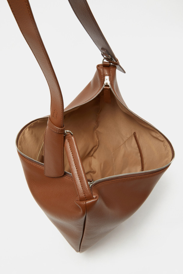 Coobo 숄더 38은 부드러운 엠보싱 소가죽 소재의 여성 숄더백입니다. 브라운 컬러의 미디엄 사이즈 가방으로, 호보백 스타일의 반원 모양 디자인과 3WAY 연출이 가능한 실용성을 갖췄습니다. 탈부착 가능한 스트랩과 내부 포켓으로 수납력을 높였으며, 클래식, 미니멀, 시크한 스타일에 잘 어울립니다. 데이트룩, 모임룩, 오피스룩 등 다양한 TPO에 활용할 수 있으며, 실버 하드웨어 장식이 은은한 포인트를 더합니다.
