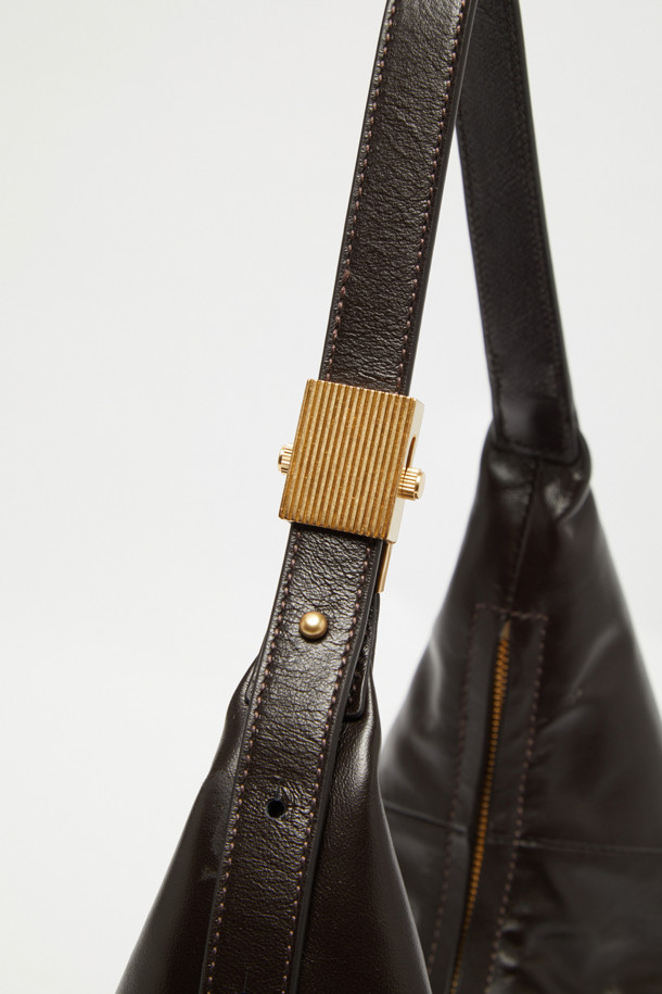 "Faugeres Cross 41" (포게레스 크로스 41)은 부드러운 소가죽 소재의 미디엄 사이즈 크로스백입니다. 블랙, 토마토 레드, 피스타치오, 그라운드 커피 4가지 색상으로 출시되었으며, 각 색상에 맞춰 실버 또는 골드 하드웨어가 사용되었습니다. 반원 형태의 디자인에 D-링 장식으로 포인트를 더했으며, 가볍고 신체 곡선에 맞춰 편안하게 착용 가능합니다. 내부에는 지퍼 포켓 1개와 오픈 포켓 1개가 있어 실용적이며, 지퍼형 잠금 방식으로 소지품을 안전하게 보관할 수 있습니다. 데이트룩, 모임룩 등 다양한 TPO에 미니멀, 클래식, 시크 스타일을 연출하기 좋습니다.
