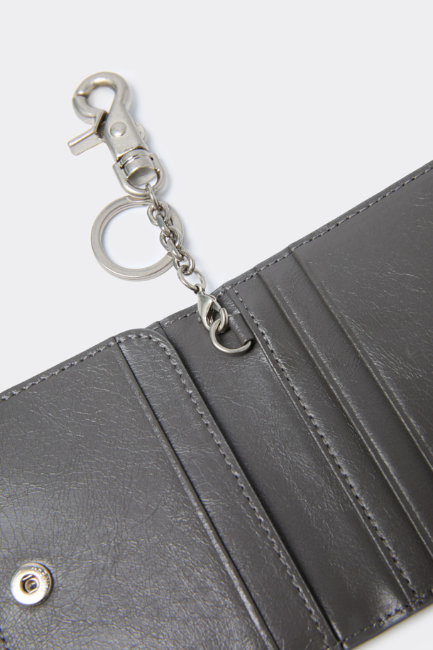 세련된 그레이 색상의 폴딩 카드지갑입니다. 미니멀한 디자인에 합성가죽 소재로 제작되어 데이트룩, 쇼핑룩, 카페룩 등 다양한 TPO에 활용하기 좋습니다. 컴팩트한 사이즈로 휴대성이 뛰어나며, 내부에는 카드 포켓 4칸과 날개 오픈포켓 1칸이 있어 수납력을 높였습니다. 또한, 로고 바 디자인 장식과 탈부착 가능한 키링으로 포인트를 더해 시크하고 클래식한 스타일을 연출합니다. 오픈형 잠금방식으로 편리하게 사용 가능합니다.
