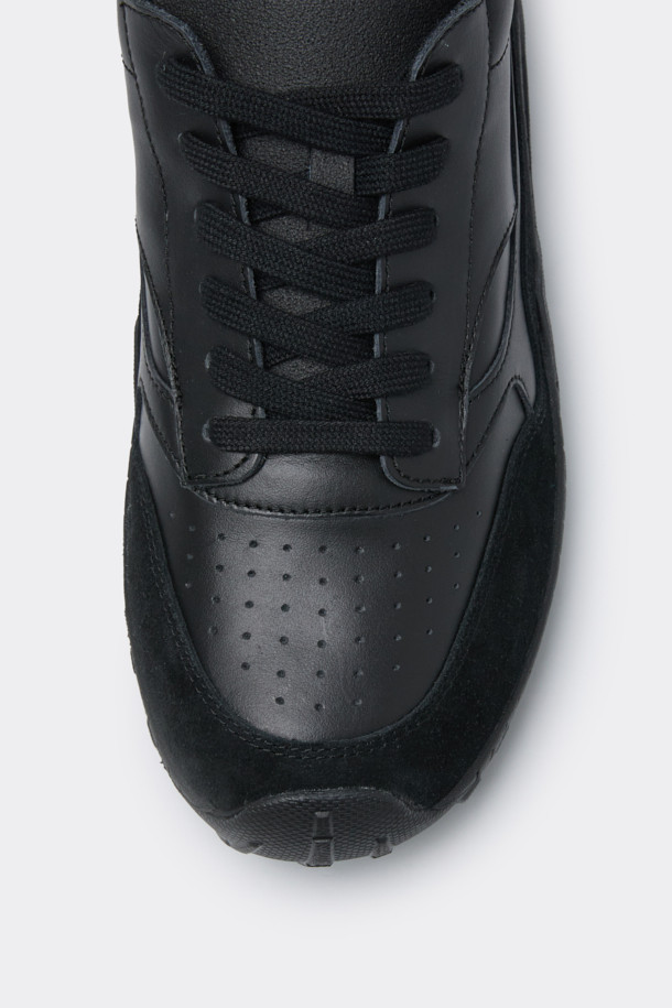 블랙 비브람 가죽 스니커즈는 남성용으로, 소가죽과 스웨이드 소재를 사용하여 제작되었습니다. 라운드 앞코에 무지 디자인으로, 베이직하고 심플한 스타일을 연출합니다. 비브람 아웃솔을 사용하여 충격 흡수와 내구성을 높였으며, 발목 부분의 볼륨감과 뒷꿈치 로고 디테일이 특징입니다. 사계절 모두 착용 가능하며, 끈으로 여미는 로우탑 디자인으로 클래식, 미니멀, 캐주얼 스타일을 모두 소화할 수 있습니다. 플랫 굽에 편안한 착용감을 제공합니다.
