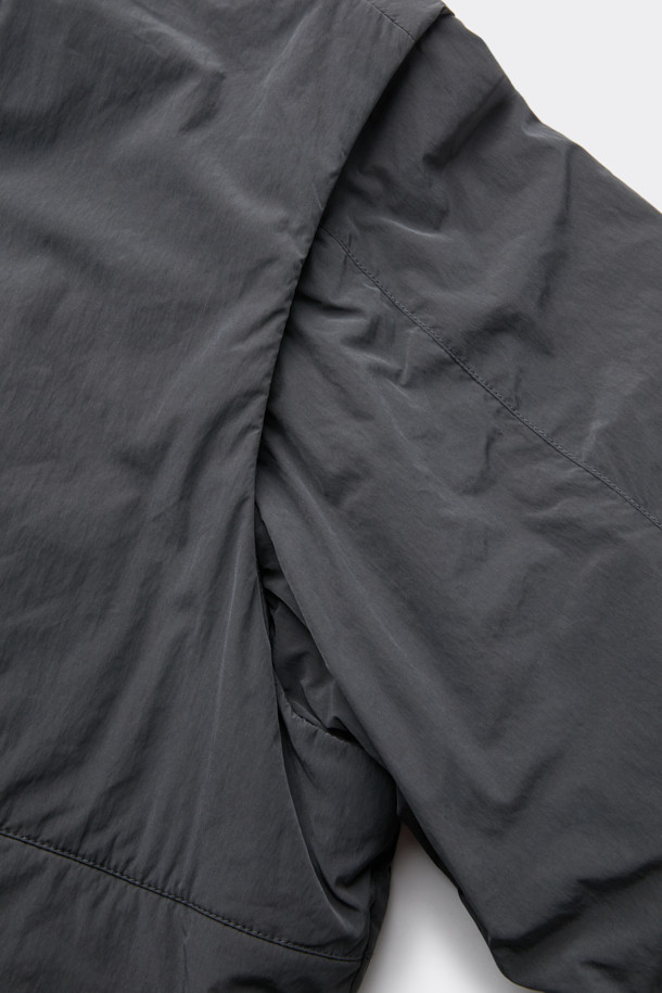 다크그레이 컬러의 탈부착 패딩 재킷입니다. 나일론과 폴리에스테르 혼방 소재로 제작되어 겨울철에도 따뜻하게 착용 가능하며, 오버핏으로 편안한 착용감을 선사합니다. 탈부착 가능한 소매 디자인으로 다양한 스타일 연출이 용이하며, 하이넥 디자인과 YKK 2-Way 지퍼, 스트링, 스토퍼 디테일이 특징입니다. 캐주얼, 미니멀, 시티보이 룩에 잘 어울리며, 출근룩과 여행룩 모두 소화 가능한 실용적인 아이템입니다.
