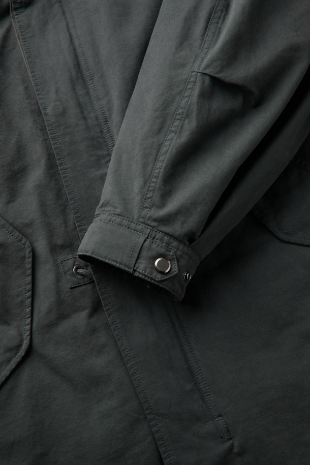 다크 그레이 컬러의 Grey Hood Liner Field Coat (그레이 후드 라이너 필드 코트)입니다. 코튼, 폴리에스테르, 나일론 혼방의 겉감과 두꺼운 두께감으로 겨울철 보온성을 높였습니다. 탈부착 가능한 다운 라이너가 포함되어 있어, 더욱 따뜻하게 착용할 수 있습니다. 허리 스트링과 YKK 2-Way 지퍼, 후드 디자인으로 캐주얼하고 미니멀한 스타일을 연출합니다. 출근룩은 물론, 일상에서도 베이직하게 활용하기 좋은 오버핏 점퍼입니다.
