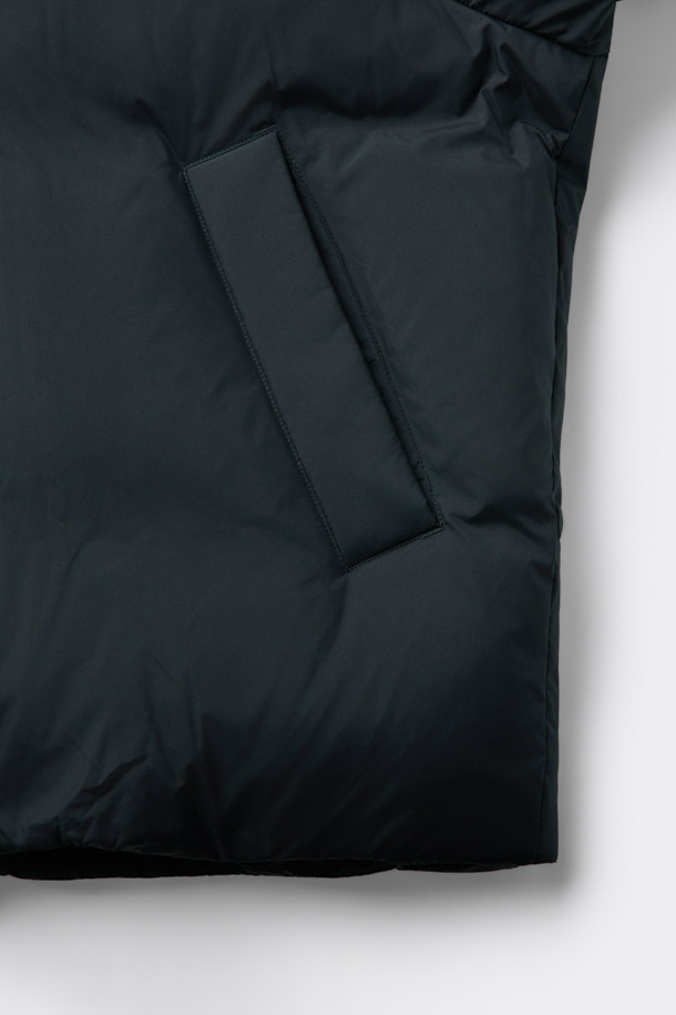 세련된 블랙 후드 숏 다운 재킷입니다. 겨울철 데일리룩에 어울리는 미니멀한 스타일의 이 재킷은 숏패딩 디자인으로 크롭 기장을 자랑합니다. 부드러운 촉감의 폴리에스테르 소재에 구스다운 80:20 충전재를 사용하여 보온성을 높였습니다. 2-Way 지퍼와 히든 여밈 방식으로 깔끔함을 더했으며, 오버핏으로 편안한 착용감을 선사합니다. 경량 소재에 은은한 광택감이 더해져 시크한 매력을 줍니다.
