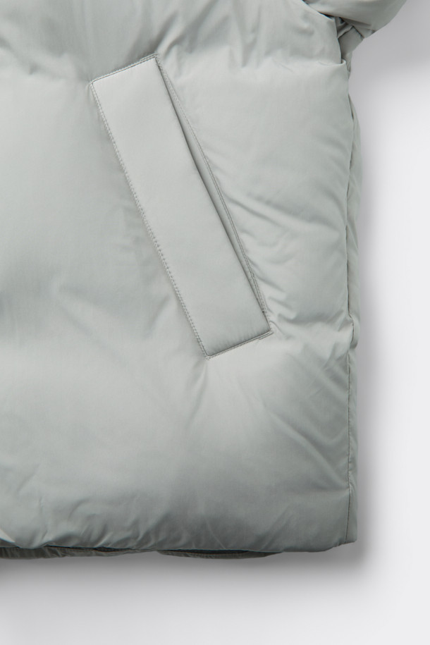 그레이 후드 숏 다운 재킷은 겨울철 데일리룩에 적합한 미니멀하고 캐주얼한 스타일의 아우터입니다. 가볍고 부드러운 폴리에스테르 소재에 80:20 구스다운 충전재를 사용하여 보온성을 높였습니다. 오버핏으로 편안하게 착용 가능하며, 2-Way 지퍼와 히든 여밈 방식으로 깔끔한 디자인을 연출합니다. 숏패딩 기장과 긴소매, 후드 디테일이 특징이며, 은은한 광택감이 고급스러운 느낌을 더합니다. 무지 디자인에 그레이 컬러로 어떤 옷에도 쉽게 매치할 수 있습니다.
