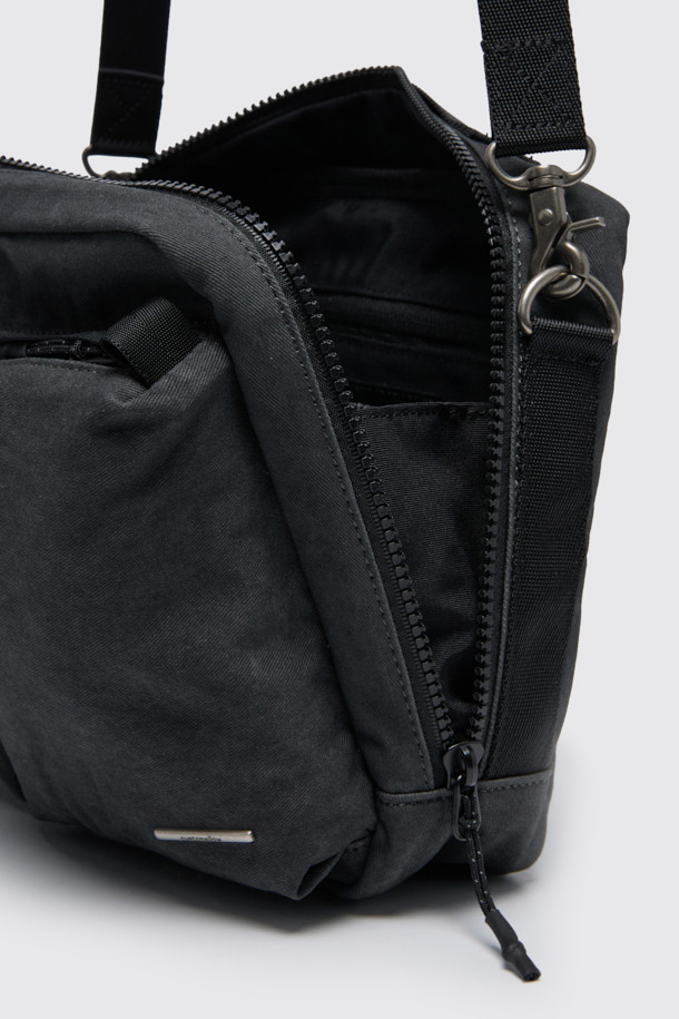 그레이 코튼 크로스백은 면 소재로 제작되어 부드러운 질감과 편안한 착용감을 선사합니다. 미디엄 사이즈의 사각 디자인에 로고 리벳 장식이 포인트로 더해져 캐주얼하면서도 미니멀한 스타일을 연출합니다. 워싱 처리된 면 소재는 자연스러운 멋을 더하며, 웨빙 손잡이와 탈부착 파우치 참으로 실용성을 높였습니다. 넉넉한 내외부 수납공간과 지퍼형 잠금 방식으로 소지품을 안전하게 보관할 수 있으며, 길이 조절이 가능한 스트랩으로 다양한 스타일을 소화할 수 있습니다. 출근룩, 비즈니스 캐주얼, 여행룩 등 다양한 TPO에 활용하기 좋은 데일리 크로스백입니다.
