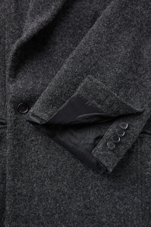 HED MAYNER (헤드 메이너)의 Grey Wool Falling Back 재킷은 모던하면서도 클래식한 스타일을 추구하는 남성을 위한 아우터입니다. 릴랙스 핏으로 편안함을 제공하며, 두꺼운 울 소재와 부드러운 촉감으로 가을과 겨울에 따뜻하게 착용할 수 있습니다. 와이드 피크드 라펠, 구조적인 어깨 패드, 후면 드레이프 디자인이 특징이며, 테일러드 코트 타입으로 오피스룩, 비즈니스 캐주얼, 모임룩 등 다양한 TPO에 활용 가능합니다. 내부 포켓과 큐프라 비스코스 혼방 안감으로 실용성과 고급스러움을 더했습니다. 미니멀하고 시크한 스타일을 선호하는 분들께 추천합니다.
