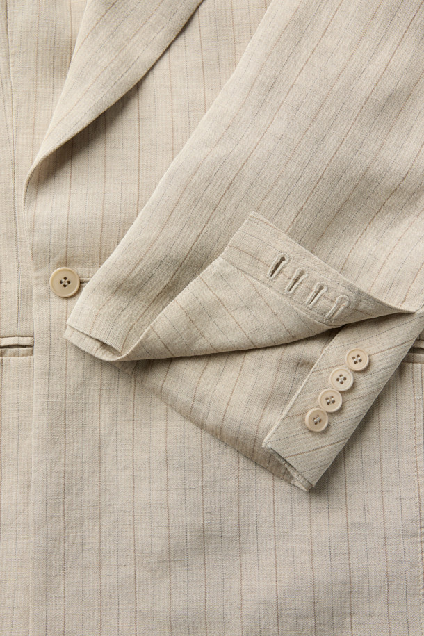 HED MAYNER (헤드 메이너)의 아이보리 린넨 Falling Back 재킷입니다. 부드러운 린넨과 레이온 혼방 소재로 제작되어 봄, 여름 시즌에 적합하며, 릴랙스 핏으로 편안한 착용감을 선사합니다. 와이드 피크드 라펠과 구조적인 어깨 패드가 특징이며, 비대칭 실루엣과 후면 드레이프 디자인으로 모던하고 미니멀한 스타일을 연출합니다. 데이트룩, 오피스룩, 비즈니스 캐주얼 등 다양한 TPO에 시크하게 매치할 수 있는 테일러드 재킷입니다. 안감은 큐프라 비스코스 소재를 사용하여 부드러운 촉감을 더했습니다.
