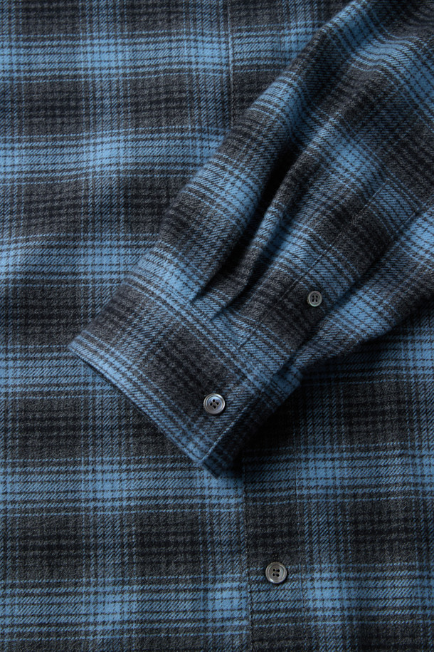 블루 오버사이즈 핏 스트링 체크 셔츠는 캐주얼 무드를 연출하는 남녀 공용 셔츠입니다. 봄, 가을 시즌에 적합하며, 데이트룩, 모임룩, 캐주얼, 클래식, 미니멀 스타일 연출에 활용할 수 있습니다. 옴브레 체크 패턴과 긴소매, 카라넥 디자인이 특징이며, 넉넉한 오버핏으로 편안한 착용감을 선사합니다. 면 소재에 스트링 디테일, 체스트 포켓, 와펜 포인트로 포인트를 더했으며, SOMELOS 유럽 수입 원단을 사용하여 고급스러운 퀄리티를 자랑합니다.
