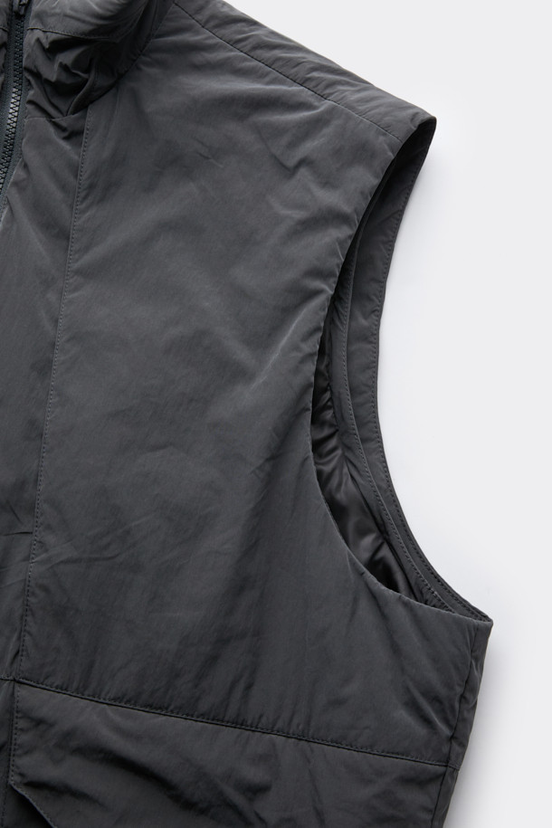 다크그레이 컬러의 탈부착 패딩 재킷입니다. 나일론과 폴리에스테르 혼방 소재로 제작되어 겨울철에도 따뜻하게 착용 가능하며, 오버핏으로 편안한 착용감을 선사합니다. 탈부착 가능한 소매 디자인으로 다양한 스타일 연출이 용이하며, 하이넥 디자인과 YKK 2-Way 지퍼, 스트링, 스토퍼 디테일이 특징입니다. 캐주얼, 미니멀, 시티보이 룩에 잘 어울리며, 출근룩과 여행룩 모두 소화 가능한 실용적인 아이템입니다.
