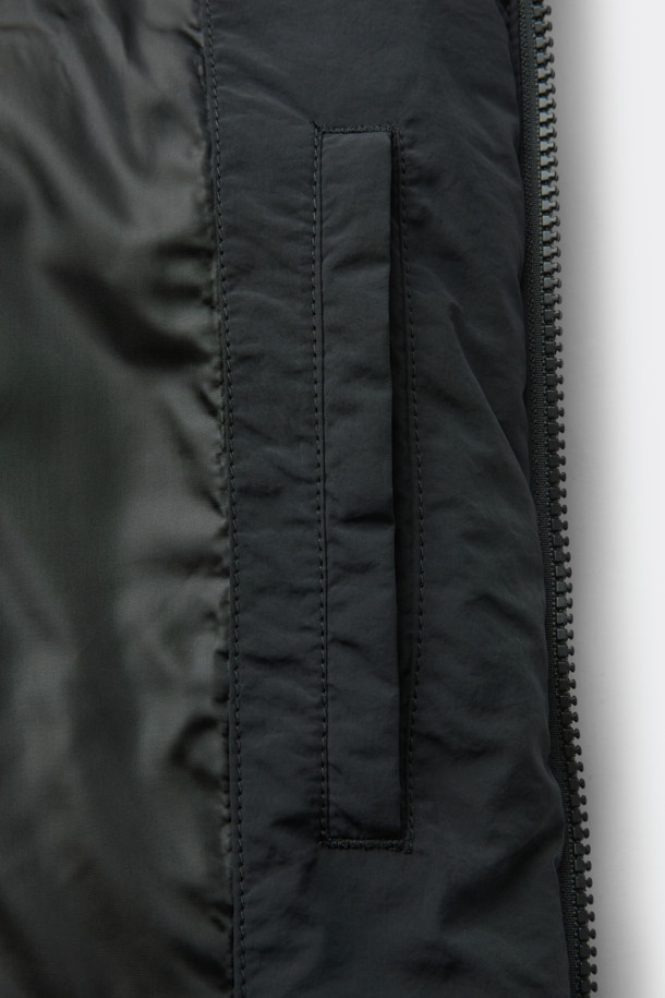 블랙 인시전 패디드 베스트는 가을과 겨울 시즌, 일상 및 출근룩, 여행룩에 모두 잘 어울리는 미니멀한 스타일의 패딩 베스트입니다. 하이넥 디자인과 YKK 2-Way 지퍼, 몸판 절개 디테일이 특징이며, 릴렉스 핏으로 편안한 착용감을 선사합니다.  나일론 소재로 제작되어 두꺼운 두께감과 은은한 광택감을 자랑하며, 무지 스타일로 어떤 룩에도 쉽게 매치할 수 있습니다. 스트링과 스토퍼 디테일이 더해져 더욱 세련된 느낌을 줍니다. 민소매 디자인으로 다양한 레이어드 연출이 가능합니다.
