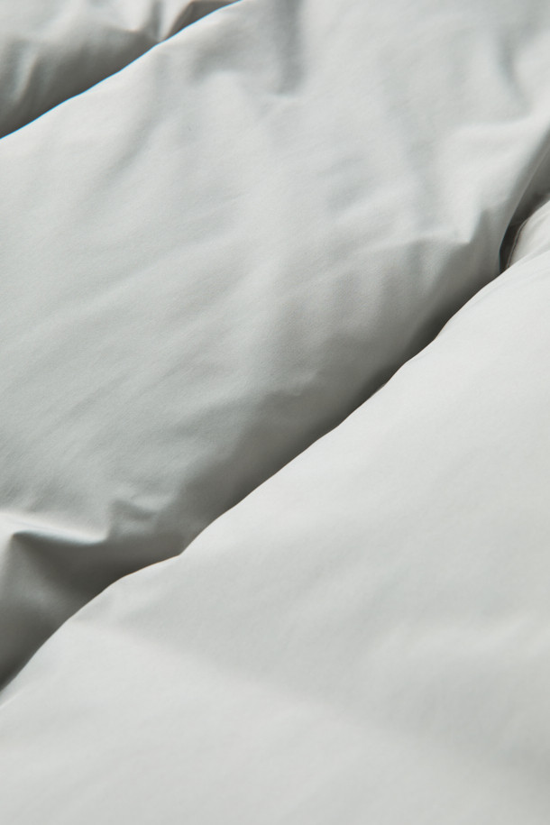 그레이 후드 숏 다운 재킷은 겨울철 데일리룩에 적합한 미니멀하고 캐주얼한 스타일의 아우터입니다. 가볍고 부드러운 폴리에스테르 소재에 80:20 구스다운 충전재를 사용하여 보온성을 높였습니다. 오버핏으로 편안하게 착용 가능하며, 2-Way 지퍼와 히든 여밈 방식으로 깔끔한 디자인을 연출합니다. 숏패딩 기장과 긴소매, 후드 디테일이 특징이며, 은은한 광택감이 고급스러운 느낌을 더합니다. 무지 디자인에 그레이 컬러로 어떤 옷에도 쉽게 매치할 수 있습니다.
