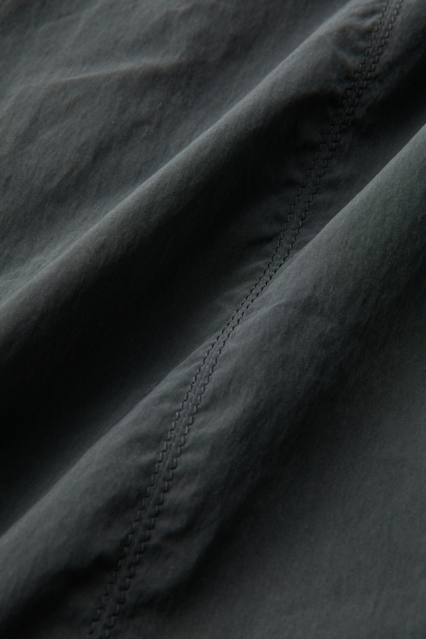 다크그레이 컬러의 Grey 사이드 지퍼 디테일 팬츠입니다. 나일론과 폴리에스테르 혼방 소재로 제작되어 사계절 내내 착용 가능하며, 은은한 광택감이 특징입니다. 와이드핏으로 편안한 착용감을 선사하며, 앞뒤 절개 디테일과 사이드 2-Way 지퍼 디테일로 포인트를 더했습니다. 하프 밴딩과 스트링으로 허리 조절이 용이하며, 출근룩, 비즈니스 캐주얼, 미니멀, 스포티, 캐주얼 스타일 모두 소화 가능한 활용도 높은 아이템입니다.
