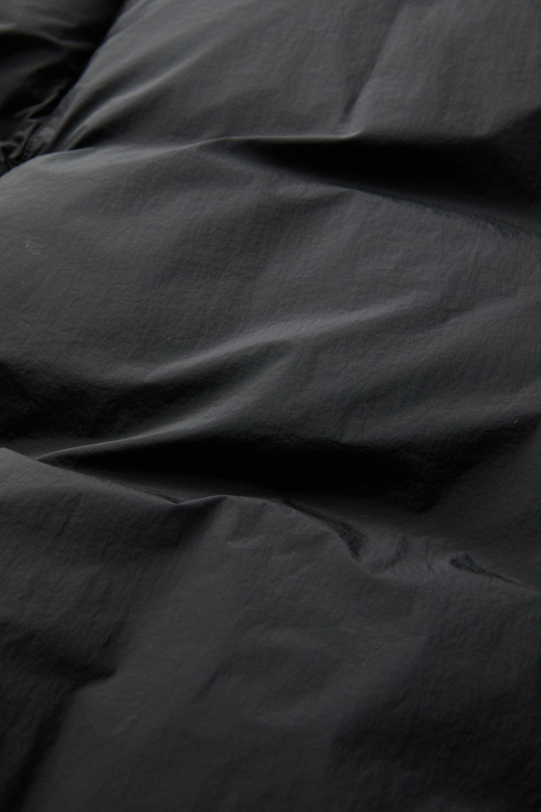 블랙 미들 후드 다운 재킷은 남성용 겨울 점퍼입니다. 미니멀하고 스포티한 스타일의 무지 디자인으로, 출근룩과 여행룩에 모두 잘 어울립니다. 가볍고 따뜻한 초경량 나일론 소재에 구스다운 80:20 충전재를 사용하여 보온성을 높였습니다. 오버핏으로 편안한 착용감을 제공하며, YKK 2-Way 지퍼와 벨크로 탈부착 후드가 특징입니다. 
