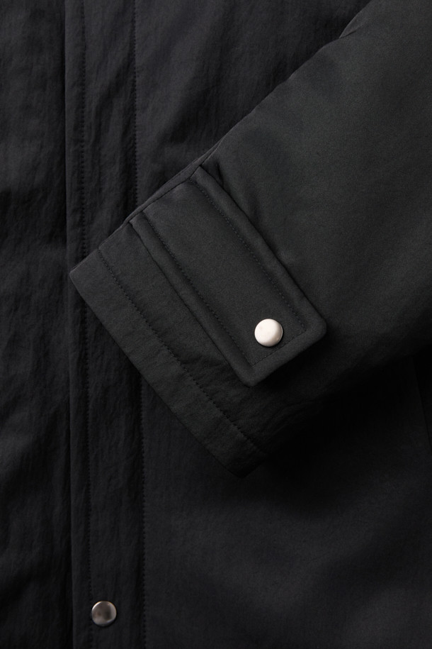 [HED MAYNER] 블랙 오버사이즈 핏 패딩 파카는 겨울철 일상과 출근룩에 모두 잘 어울리는 남성용 점퍼입니다. 부드러운 나일론 소재와 두꺼운 두께감으로 보온성을 높였으며, 오버핏 디자인과 라운드 숄더, 소매 스트랩 디테일이 특징입니다. 퀼팅 안감과 내외부 포켓 구성으로 실용성을 더했으며, 지퍼 여밈 방식으로 간편하게 착용할 수 있습니다. 미니멀하고 시크한 스타일을 연출하기에 좋으며, 다양한 룩에 활용하기 용이합니다.
