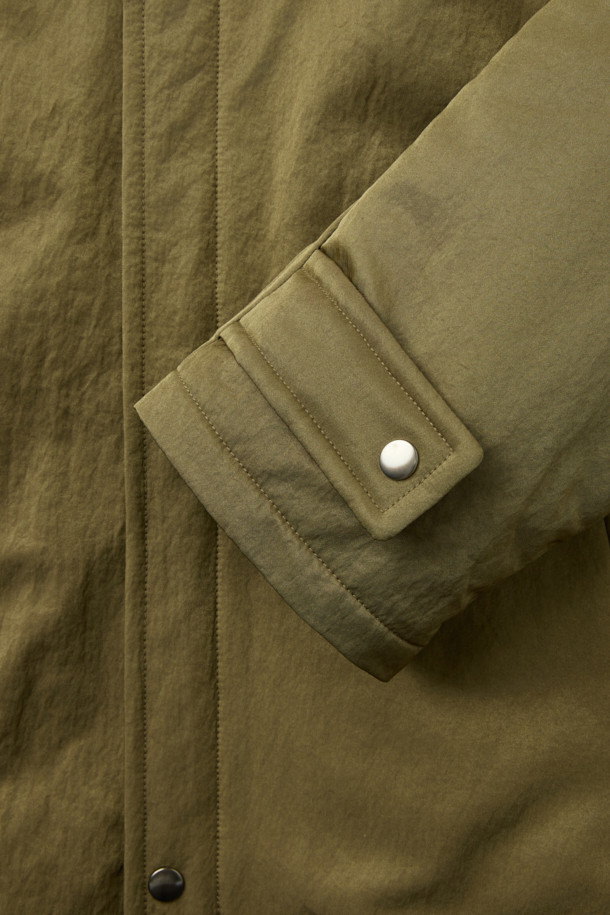 [HED MAYNER] 골드 오버사이즈 핏 패딩 파카는 겨울철 일상과 출근룩에 모두 잘 어울리는 남성용 아우터입니다. 모던한 무드의 무지 디자인에 오버핏으로 제작되어 편안하면서도 세련된 스타일을 연출합니다. 두꺼운 두께감의 나일론 소재와 퀼팅 안감으로 보온성을 높였으며, 구조적인 패턴과 소매 스트랩 디테일이 특징입니다. 집업 스타일로 간편하게 착용 가능하며, 내부 및 외부 포켓과 포켓 하단 포인트 라벨이 실용성을 더합니다. 미니멀, 클래식, 시크한 스타일을 즐기는 분들께 추천하는 패딩입니다.
