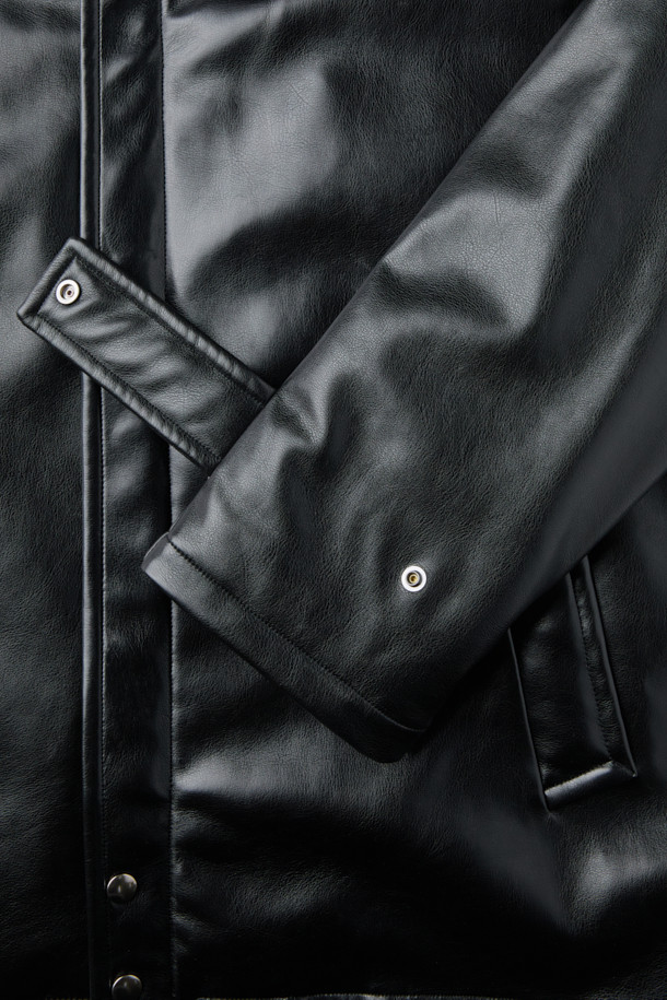 HED MAYNER (헤드 메이너)의 블랙 페이크 레더 패디드 파카는 겨울철 일상에서 모던하고 미니멀한 스타일을 연출하기에 완벽한 아우터입니다. 부드러운 합성 가죽 소재에 넉넉한 오버핏 실루엣으로 편안한 착용감을 선사하며, 퀼팅 안감과 두꺼운 두께로 뛰어난 보온성을 제공합니다. 라운드 숄더, 소매 스트랩, 내/외부 포켓, YKK 2-Way 지퍼, 은은한 광택감 등의 디테일이 돋보이며, 긴 소매 기장으로 세련된 분위기를 더합니다. 시크하고 캐주얼한 스타일을 즐기는 남성분들께 추천하는 아이템입니다.
