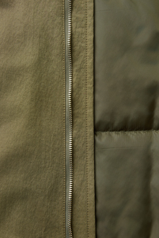 [HED MAYNER] 골드 오버사이즈 핏 패딩 파카는 겨울철 일상과 출근룩에 모두 잘 어울리는 남성용 아우터입니다. 모던한 무드의 무지 디자인에 오버핏으로 제작되어 편안하면서도 세련된 스타일을 연출합니다. 두꺼운 두께감의 나일론 소재와 퀼팅 안감으로 보온성을 높였으며, 구조적인 패턴과 소매 스트랩 디테일이 특징입니다. 집업 스타일로 간편하게 착용 가능하며, 내부 및 외부 포켓과 포켓 하단 포인트 라벨이 실용성을 더합니다. 미니멀, 클래식, 시크한 스타일을 즐기는 분들께 추천하는 패딩입니다.
