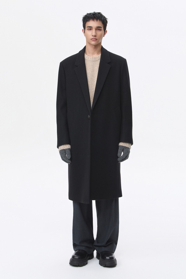 남성용 블랙 오버사이즈 핏 노치드 라펠 코트입니다. 가을, 겨울 시즌에 어울리는 두꺼운 두께감으로, 울, 나일론, 캐시미어 혼방 소재로 제작되어 부드러운 촉감과 보온성을 제공합니다. 미니멀, 클래식 스타일을 기반으로 하여 출근룩, 오피스룩, 모임룩 등 다양한 TPO에 활용 가능합니다. 싱글 버튼 여밈 방식과 롱 기장, 긴 소매 디자인으로 시크한 매력을 더하며, 오버핏으로 편안한 착용감을 선사합니다.

