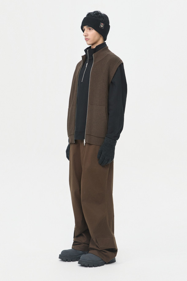 부드러운 촉감의 브라운 터틀넥 집업 베스트입니다. 면 60.2%와 울 39.8% 혼방 소재로 제작되어 간절기에 적합하며, 얇은 두께감으로 편안하게 착용할 수 있습니다. 12GG 골지 패턴으로 베이직한 스타일을 연출하며, 레귤러핏으로 다양한 스타일에 활용할 수 있습니다. 2-Way 지퍼 디테일이 돋보이며, 비즈니스 캐주얼 및 출근룩에 클래식하고 미니멀한 무드를 더해줍니다. 민소매 디자인으로 레이어드하기 좋습니다.
