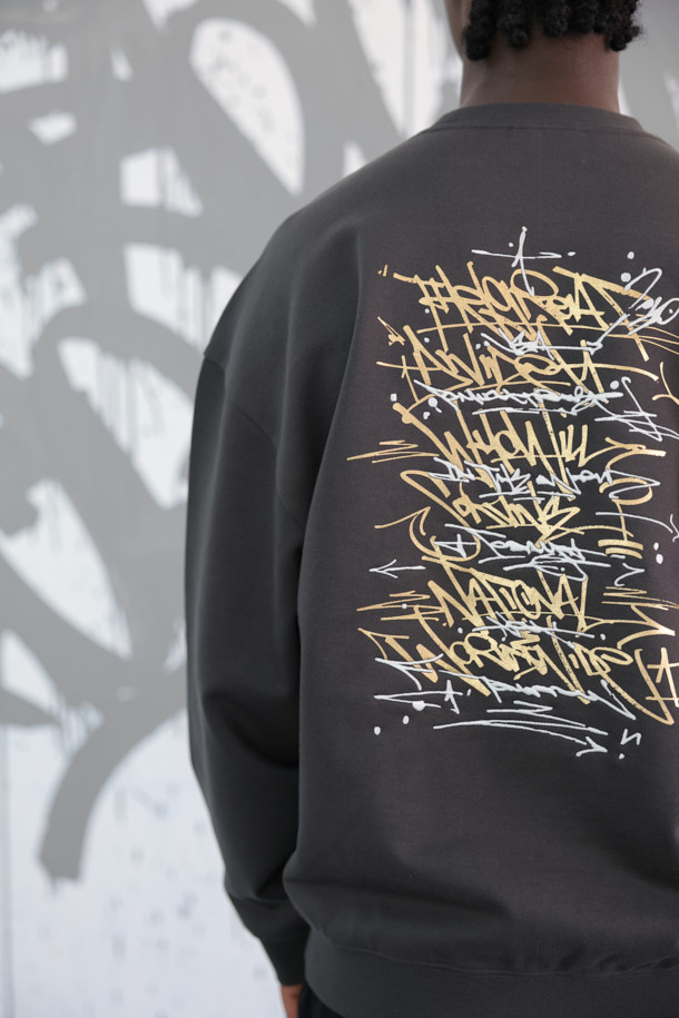 [비스코 스미스] 그레이 그래픽 스웨트셔츠는 BISCO SMITH 작가의 'HoldTheGround' 작품을 모티브로 한 유니크한 디자인이 돋보이는 제품입니다. 전면에는 작가의 시그니처 프린트가, 후면에는 프린트와 자수 디테일이 더해져 소장 가치를 높였습니다. 릴랙스 핏과 두꺼운 면 소재로 제작되어 가을, 겨울철 데일리룩과 동네 마실룩에 적합하며, 캐주얼, 스트리트, 미니멀 스타일을 즐겨 입는 분들께 추천합니다. 라운드넥과 긴소매 디자인으로 편안한 착용감을 제공하며, 그레이 컬러는 어떤 룩에도 쉽게 매치할 수 있어 활용도가 높습니다.
