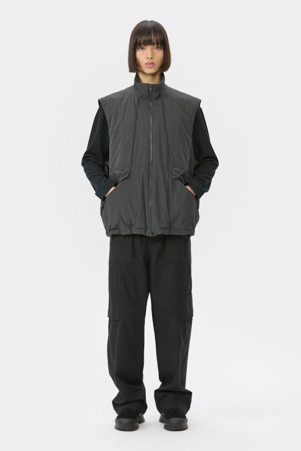 다크그레이 컬러의 탈부착 패딩 재킷입니다. 나일론과 폴리에스테르 혼방 소재로 제작되어 겨울철에도 따뜻하게 착용 가능하며, 오버핏으로 편안한 착용감을 선사합니다. 탈부착 가능한 소매 디자인으로 다양한 스타일 연출이 용이하며, 하이넥 디자인과 YKK 2-Way 지퍼, 스트링, 스토퍼 디테일이 특징입니다. 캐주얼, 미니멀, 시티보이 룩에 잘 어울리며, 출근룩과 여행룩 모두 소화 가능한 실용적인 아이템입니다.
