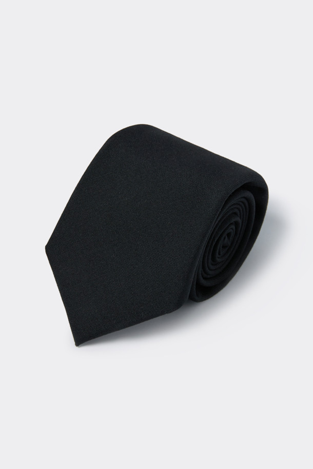 블랙 울 솔리드 타이는 포르투갈 피테콤사의 울 혼방 소재로 제작되어 고급스러운 착용감을 선사합니다. 톤온톤의 무지 디자인과 세미 세븐 폴드 디자인 장식이 더해져 클래식하면서도 세련된 스타일을 연출합니다. 넥타이 안감을 추가하여 내구성을 높였으며, 수입 라벨 디테일로 품격을 더했습니다. 오피스룩, 회의룩, 면접룩 등 격식 있는 자리에 잘 어울리며, 미니멀한 디자인으로 어떤 스타일에도 매치하기 좋습니다. 탄탄한 두께감으로 넥타이의 형태를 오랫동안 유지합니다.