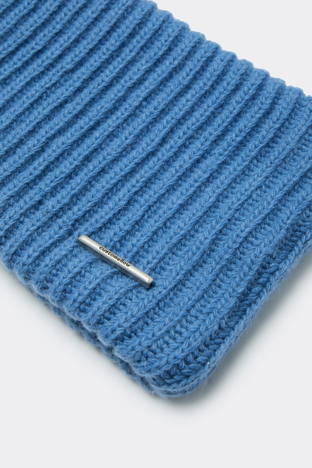 세련된 블루 니트 귀마개입니다. 캐시미어와 울 소재 혼방으로 제작되어 부드러운 촉감과 뛰어난 보온성을 자랑하며, 겨울철 추위로부터 귀를 따뜻하게 보호해 줍니다. 골지 패턴으로 디자인되어 클래식하면서도 미니멀한 스타일을 연출하며, 로고 장식으로 포인트를 더했습니다. 출근룩이나 연말 모임룩 등 다양한 TPO에 활용 가능하며, 캐주얼한 스타일에도 잘 어울립니다.
