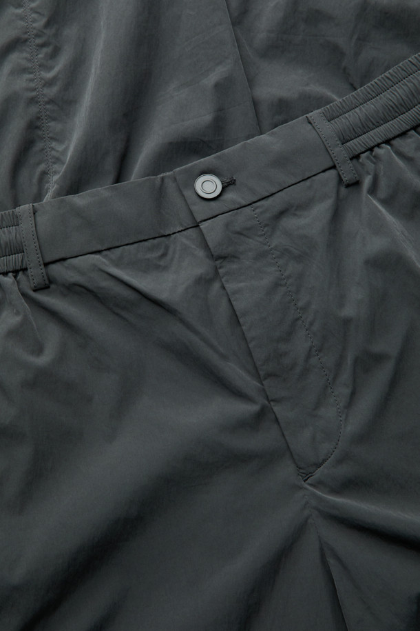 다크그레이 컬러의 Grey 사이드 지퍼 디테일 팬츠입니다. 나일론과 폴리에스테르 혼방 소재로 제작되어 사계절 내내 착용 가능하며, 은은한 광택감이 특징입니다. 와이드핏으로 편안한 착용감을 선사하며, 앞뒤 절개 디테일과 사이드 2-Way 지퍼 디테일로 포인트를 더했습니다. 하프 밴딩과 스트링으로 허리 조절이 용이하며, 출근룩, 비즈니스 캐주얼, 미니멀, 스포티, 캐주얼 스타일 모두 소화 가능한 활용도 높은 아이템입니다.
