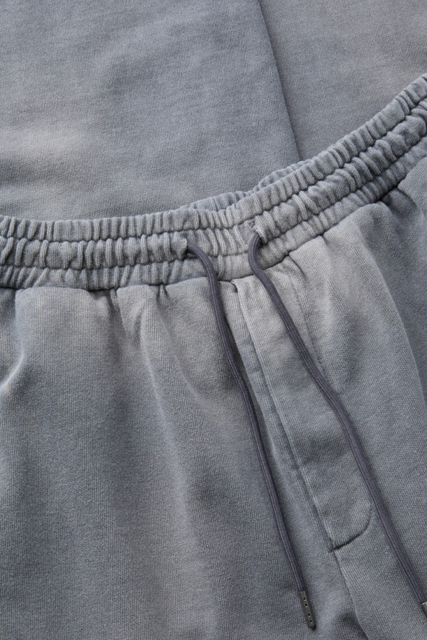 그레이 염색 스웻 팬츠는 부드러운 면 소재로 제작되어 편안한 착용감을 선사합니다. 루즈핏으로 제작되어 캐주얼하고 스포티한 스타일을 연출하며, 봄, 가을, 겨울 모두 활용 가능합니다. 다잉 가공과 탈색 브러쉬 가공으로 빈티지한 멋을 더했으며, 허리 스트링과 밑단 스트링 스토퍼 디테일로 실용성을 높였습니다. 집콕, 산책, 여행 등 다양한 TPO에 활용하기 좋은 데일리 아이템입니다.
