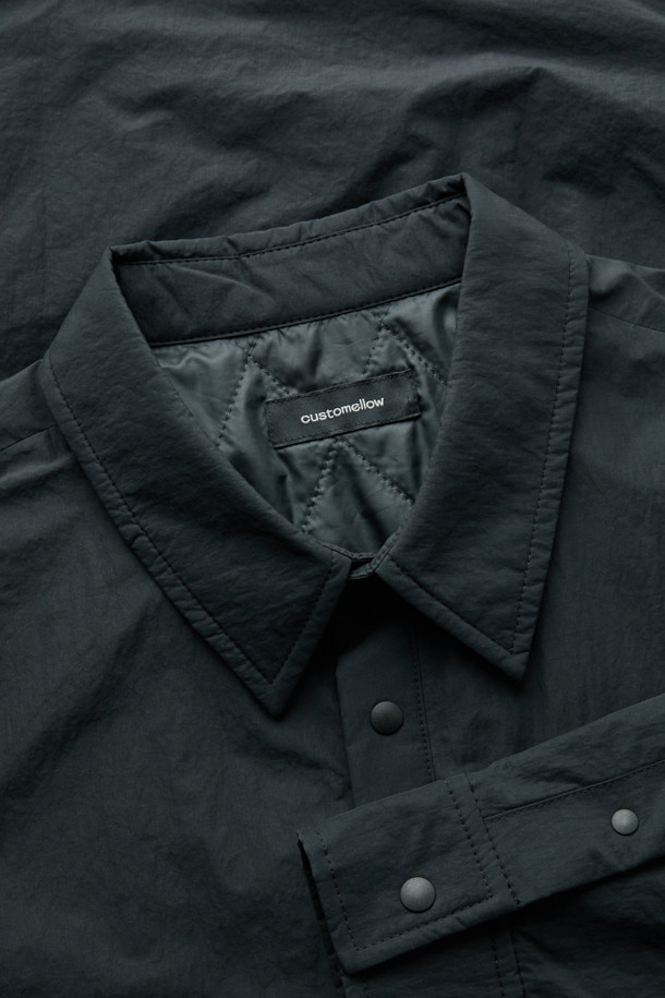 블랙 패딩 아우터 셔츠는 남성용 캐주얼 패딩셔츠입니다. 가을과 겨울에 착용하기 좋으며, 차이나칼라와 긴 소매, 무지 패턴으로 미니멀한 스타일을 연출합니다. 초경량 하스 충전재를 사용하여 보온성을 높였으며, 퀼팅 안감으로 부드러운 착용감을 제공합니다. 밑단 스트링 디테일과 우레탄 라벨 포인트가 특징이며, 핏은 오버핏으로 제작되었습니다. 면과 나일론 혼방 소재로 제작되어 편안함과 내구성을 동시에 갖췄습니다.
