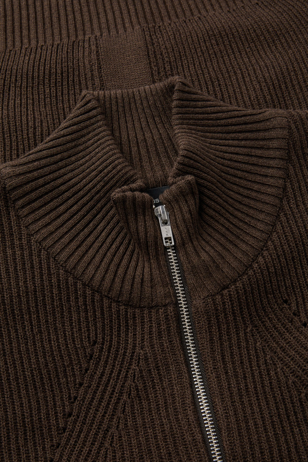 부드러운 촉감의 브라운 터틀넥 집업 베스트입니다. 면 60.2%와 울 39.8% 혼방 소재로 제작되어 간절기에 적합하며, 얇은 두께감으로 편안하게 착용할 수 있습니다. 12GG 골지 패턴으로 베이직한 스타일을 연출하며, 레귤러핏으로 다양한 스타일에 활용할 수 있습니다. 2-Way 지퍼 디테일이 돋보이며, 비즈니스 캐주얼 및 출근룩에 클래식하고 미니멀한 무드를 더해줍니다. 민소매 디자인으로 레이어드하기 좋습니다.
