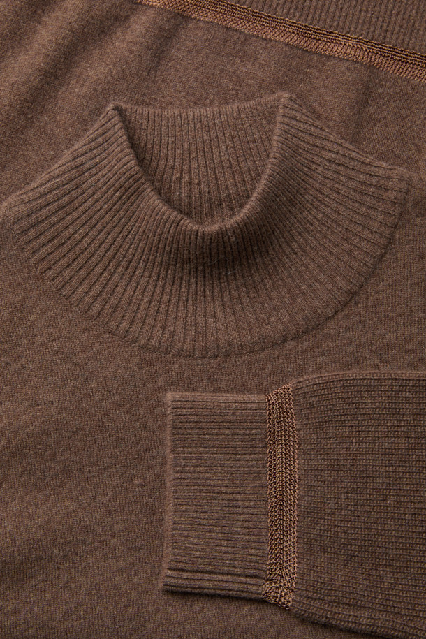 남성용 브라운 터틀넥 스웨터입니다. 가을과 겨울에 어울리는 두꺼운 두께감의 울 소재로 제작되어 부드러운 촉감을 선사합니다. 베이직하고 미니멀한 스타일로, 레귤러 핏과 긴 소매 기장으로 편안함을 더했습니다. 하찌 조직 소매와 자수사 배색 디테일이 특징이며, 데일리룩에 클래식한 무드를 더해줍니다. 일상생활에서 폭넓게 활용하기 좋은 아이템입니다.
