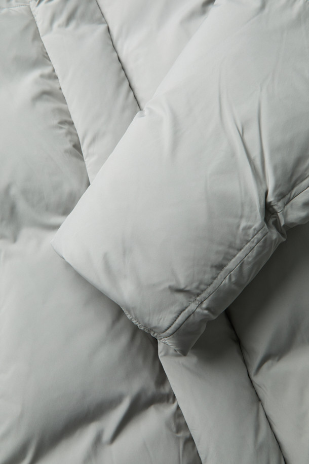 그레이 후드 숏 다운 재킷은 겨울철 데일리룩에 적합한 미니멀하고 캐주얼한 스타일의 아우터입니다. 가볍고 부드러운 폴리에스테르 소재에 80:20 구스다운 충전재를 사용하여 보온성을 높였습니다. 오버핏으로 편안하게 착용 가능하며, 2-Way 지퍼와 히든 여밈 방식으로 깔끔한 디자인을 연출합니다. 숏패딩 기장과 긴소매, 후드 디테일이 특징이며, 은은한 광택감이 고급스러운 느낌을 더합니다. 무지 디자인에 그레이 컬러로 어떤 옷에도 쉽게 매치할 수 있습니다.
