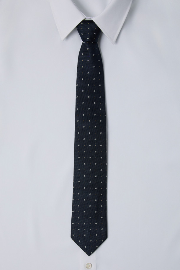 네이비 플라워 타이입니다. 100% 실크 소재로 제작되어 부드러운 촉감이 특징이며, 사계절 내내 착용하기 좋습니다. 클래식한 디자인에 네이비 컬러 바탕에 플라워 패턴이 섬세하게 조화롭게 어우러져 세련된 분위기를 연출합니다. 안감에는 로고 자수 디테일이 돋보이며, 오피스룩, 비즈니스 캐주얼, 회의룩 등 다양한 TPO에 활용 가능합니다. 클래식, 미니멀 스타일을 선호하는 남성분들께 추천합니다.
