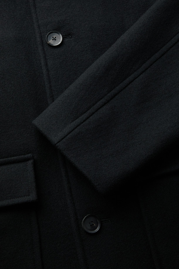 블랙 울 카 코트는 남성 고객을 위한 미니멀하고 클래식한 스타일의 아우터입니다. 가을과 겨울에 착용하기 좋은 두꺼운 두께감의 롱 기장 코트로, 울과 나일론 혼방 소재로 제작되었습니다. 차분한 블랙 컬러에 무지 패턴, 오버핏 디자인으로 시크한 매력을 더합니다. 버튼 여밈 방식과 아웃포켓 디테일이 특징이며, 출근룩, 오피스룩, 모임룩 등 다양한 TPO에 활용할 수 있습니다. 
