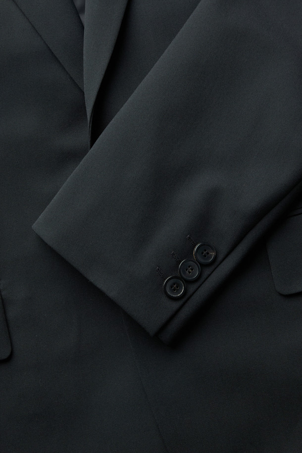 블랙 색상의 릴랙스 핏 울 블렌디드 셋업 재킷입니다. 가을과 겨울에 입기 좋은 두꺼운 두께감으로, 차분하고 시크한 스타일을 연출합니다. 싱글 버튼 디자인과 레귤러 기장으로 클래식하면서도 베이직한 분위기를 강조하며, 셋업으로도 활용 가능합니다. 울과 폴리에스터 혼방 소재로 제작되어 편안한 착용감을 선사합니다. 오피스룩, 비즈니스 캐주얼, 모임룩 등 다양한 TPO에 활용하여 세련된 스타일을 완성해 보세요.
