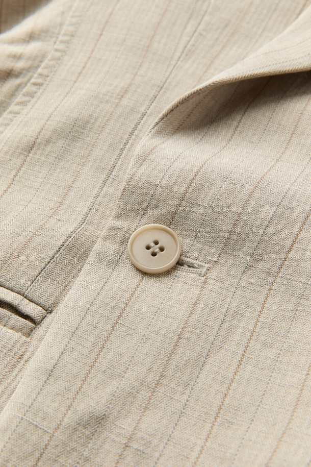 HED MAYNER (헤드 메이너)의 아이보리 린넨 Falling Back 재킷입니다. 부드러운 린넨과 레이온 혼방 소재로 제작되어 봄, 여름 시즌에 적합하며, 릴랙스 핏으로 편안한 착용감을 선사합니다. 와이드 피크드 라펠과 구조적인 어깨 패드가 특징이며, 비대칭 실루엣과 후면 드레이프 디자인으로 모던하고 미니멀한 스타일을 연출합니다. 데이트룩, 오피스룩, 비즈니스 캐주얼 등 다양한 TPO에 시크하게 매치할 수 있는 테일러드 재킷입니다. 안감은 큐프라 비스코스 소재를 사용하여 부드러운 촉감을 더했습니다.
