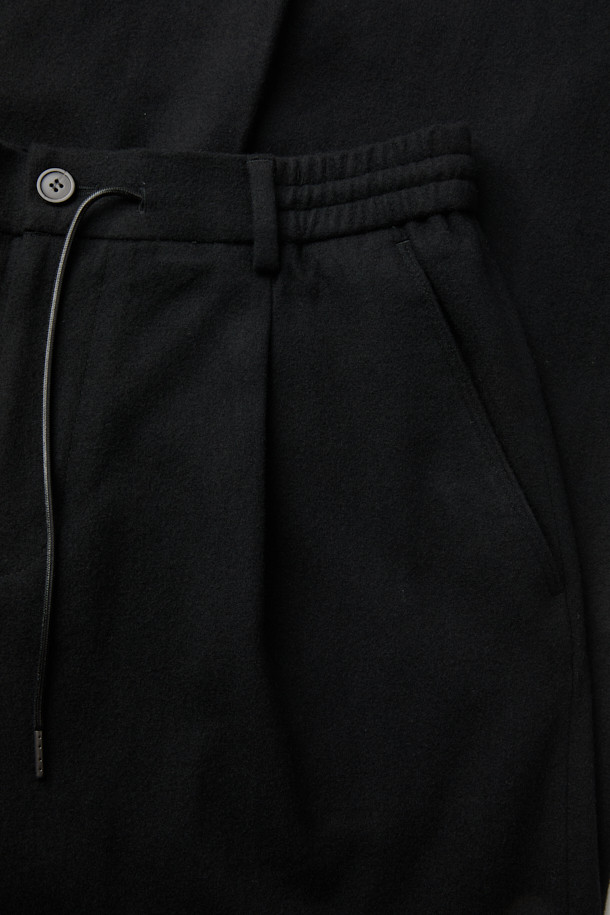 블랙 와이드 핏 턱 울 팬츠는 가을과 겨울에 어울리는 클래식 스타일의 울 팬츠입니다. 넉넉한 루즈핏 와이드 실루엣으로 편안하면서도 시크한 무드를 연출합니다. 턱 디테일과 밑단 스트링으로 디자인 포인트를 더했으며, 히든 스냅 소매로 깔끔함을 강조했습니다. 오피스룩, 출근룩, 모임룩 등 다양한 TPO에 활용 가능하며, 미니멀하고 시크한 스타일을 완성합니다.
