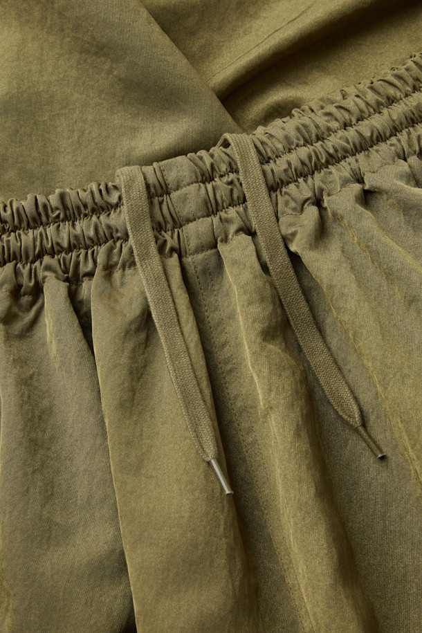 [HED MAYNER] 골드 나일론 유도 팬츠는 이탈리안 나일론 원단으로 제작되어 부드러운 촉감과 은은한 광택감이 돋보입니다. 허리 주름 디테일과 내부 스트링, 포켓 하단의 포인트 라벨이 특징이며, 벌룬핏과 루즈핏으로 편안하면서도 볼륨감 있는 실루엣을 연출합니다. 여행룩, 산책룩 등 다양한 TPO에 활용 가능하며, 미니멀, 캐주얼, 시티보이 스타일을 즐겨 입는 분들께 추천합니다. 무지 디자인으로 어떤 상의와도 매치하기 용이하여 데일리 팬츠로 활용하기 좋습니다.
