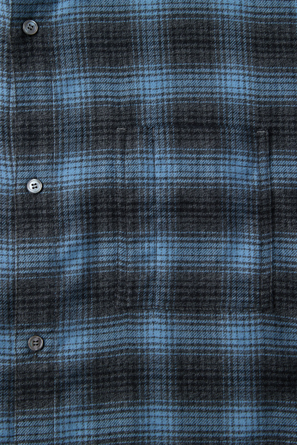 블루 오버사이즈 핏 스트링 체크 셔츠는 캐주얼 무드를 연출하는 남녀 공용 셔츠입니다. 봄, 가을 시즌에 적합하며, 데이트룩, 모임룩, 캐주얼, 클래식, 미니멀 스타일 연출에 활용할 수 있습니다. 옴브레 체크 패턴과 긴소매, 카라넥 디자인이 특징이며, 넉넉한 오버핏으로 편안한 착용감을 선사합니다. 면 소재에 스트링 디테일, 체스트 포켓, 와펜 포인트로 포인트를 더했으며, SOMELOS 유럽 수입 원단을 사용하여 고급스러운 퀄리티를 자랑합니다.

