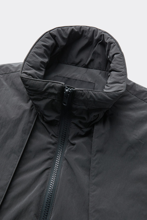 다크그레이 컬러의 탈부착 패딩 재킷입니다. 나일론과 폴리에스테르 혼방 소재로 제작되어 겨울철에도 따뜻하게 착용 가능하며, 오버핏으로 편안한 착용감을 선사합니다. 탈부착 가능한 소매 디자인으로 다양한 스타일 연출이 용이하며, 하이넥 디자인과 YKK 2-Way 지퍼, 스트링, 스토퍼 디테일이 특징입니다. 캐주얼, 미니멀, 시티보이 룩에 잘 어울리며, 출근룩과 여행룩 모두 소화 가능한 실용적인 아이템입니다.
