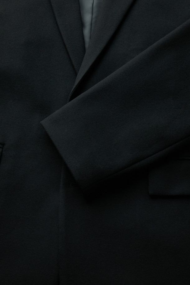 블랙 루즈 핏 셋업 재킷입니다. 레이온, 폴리에스테르, 폴리우레탄 혼방 소재로 제작되어 부드러운 촉감과 중량감을 느낄 수 있습니다. 싱글 버튼 여밈 방식의 레귤러 기장 블레이저 스타일이며, 넉넉한 루즈핏으로 편안하게 착용 가능합니다. 봄, 가을에 출근룩, 비즈니스 캐주얼, 모임룩 등 다양한 TPO에 맞춰 클래식, 미니멀, 시크한 스타일을 연출하기 좋습니다. 무지 디자인으로 어떤 옷에도 쉽게 매치할 수 있는 베이직한 아이템입니다.
