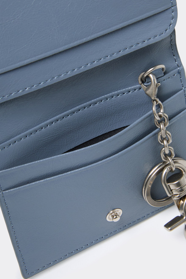 세련된 블루 컬러의 폴딩 카드지갑입니다. 미니 크링클 가죽과 합성피혁 소재로 제작되었으며, 미니멀한 디자인과 사각 쉐입이 특징입니다. 탈부착 가능한 키링과 좌우 4칸의 카드 포켓, 날개 오픈 포켓 1칸으로 실용성을 더했습니다. 데이트룩, 쇼핑룩, 카페룩 등 다양한 TPO에 미니멀, 클래식, 시크 스타일을 연출하기 좋은 아이템입니다. 로고 바 장식이 고급스러움을 더하는 컴팩트한 사이즈의 지갑입니다.
