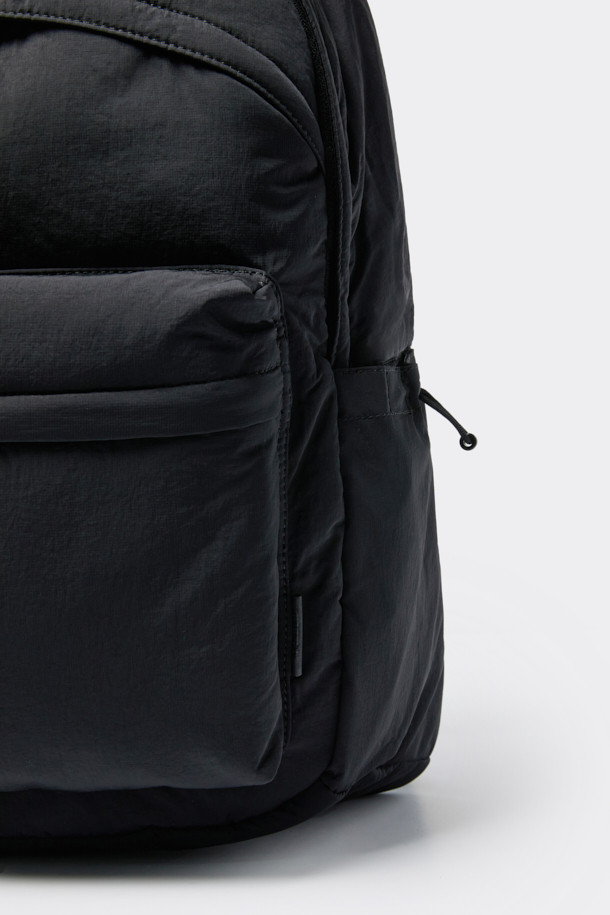 블랙 나일론 백팩은 남성을 위한 미니멀, 캐주얼, 시티보이 스타일의 가방입니다. 튼튼한 나일론 소재로 제작되어 생활 방수 기능과 뛰어난 내구성을 자랑하며, 사각 형태에 로고 디자인으로 포인트를 더했습니다. 내부에는 노트북 수납 공간이, 외부에는 전면 2단 오픈 포켓, 전면 포켓, 사이드 포켓이 있어 수납력을 높였습니다. 지퍼와 벨크로형 잠금 방식으로 내용물을 안전하게 보호하며, 조절 가능한 숄더 스트랩과 상단 핸들로 편안한 착용감을 제공합니다. 출근룩, 여행룩, 워크샵룩 등 다양한 TPO에 활용하기 좋습니다.
