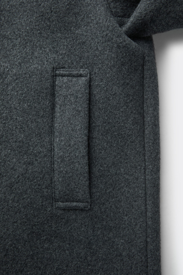 멜란지 그레이 컬러의 남성용 하이넥 코트입니다. 울과 나일론 혼방 소재로 제작되어 가을, 겨울 시즌에 적합하며, 두꺼운 두께감으로 보온성을 높였습니다. 래글런 소매 디테일이 돋보이는 레귤러핏 코트로, 버튼 여밈 방식과 무지 디자인으로 베이직하면서도 미니멀한 스타일을 연출합니다. 출근룩, 비즈니스 캐주얼, 모임룩 등 다양한 TPO에 활용 가능하며, 클래식, 미니멀, 시크한 스타일을 완성합니다.
