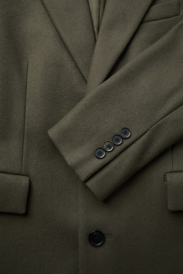 베이지 색상의 오버핏 피크드 라펠 코트입니다. 울, 나일론, 캐시미어 혼방 소재로 제작되어 가을, 겨울 시즌에 따뜻하게 착용할 수 있습니다. 미니멀하고 클래식한 스타일로, 출근룩, 오피스룩, 모임룩 등 다양한 TPO에 활용 가능합니다. 싱글 버튼 여밈 방식으로 깔끔하며, 롱 기장과 오버핏 실루엣이 시크한 분위기를 연출합니다. 무지 디자인으로 어떤 옷에도 쉽게 매치할 수 있는 데일리 코트입니다.
