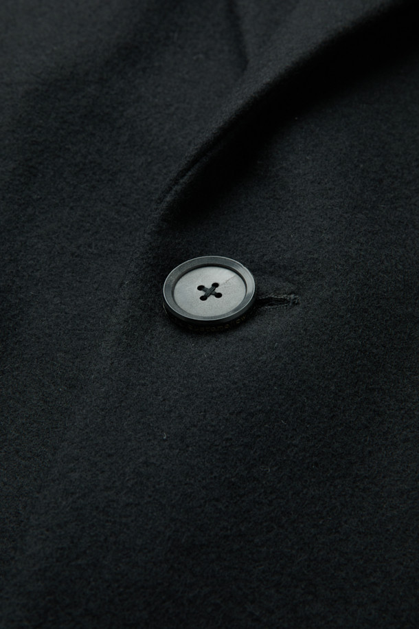 남성용 블랙 오버사이즈 핏 노치드 라펠 코트입니다. 가을, 겨울 시즌에 어울리는 두꺼운 두께감으로, 울, 나일론, 캐시미어 혼방 소재로 제작되어 부드러운 촉감과 보온성을 제공합니다. 미니멀, 클래식 스타일을 기반으로 하여 출근룩, 오피스룩, 모임룩 등 다양한 TPO에 활용 가능합니다. 싱글 버튼 여밈 방식과 롱 기장, 긴 소매 디자인으로 시크한 매력을 더하며, 오버핏으로 편안한 착용감을 선사합니다.
