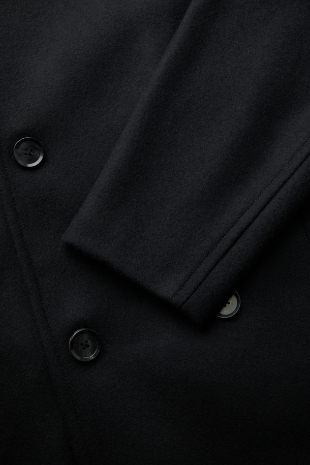 블랙 울 피코트는 클래식과 미니멀 무드를 동시에 연출하는 남성용 아우터입니다. 이탈리아 FORTEX 소재의 고급 울, 나일론, 캐시미어 혼방으로 제작되어 두꺼운 두께감과 매트한 촉감을 자랑합니다. 더블 버튼 여밈과 릴랙스 핏 디자인은 편안하면서도 세련된 스타일을 선사하며, 가을과 겨울철 출근룩, 비즈니스 캐주얼, 모임룩 등 다양한 TPO에 활용 가능합니다. 기본에 충실한 디자인으로 시크한 매력을 더하여 당신의 옷장에 품격을 더해줄 것입니다. 
